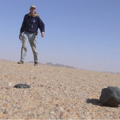 Peter Jenniskens en busca de los meteoritos en el desierto de Sudán y detalle de uno de ellos (abajo).