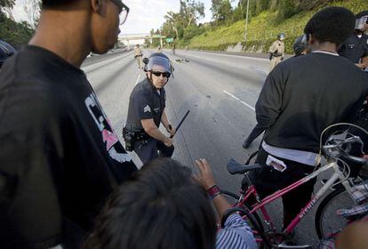 Un policía, enfrente de manifestantes en una protesta en una carretera de Los Ángeles.