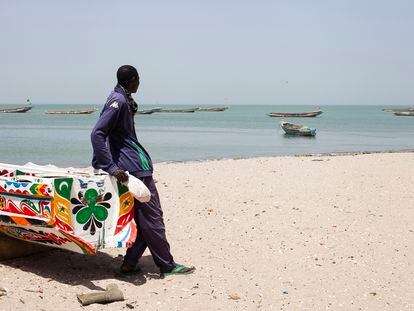 Mor Ndiaye, padre de Ass Ndiaye, en la playa de Joal, Senegal, frente a su cayuco.