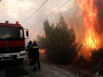 Los bomeros tratan de extinguir un incendio en Penteli, al norte de Atenas (Grecia), este lunes.