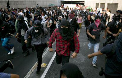 Manifestantes enmascarados durante la protesta del 2 de octubre en M&eacute;xico DF.