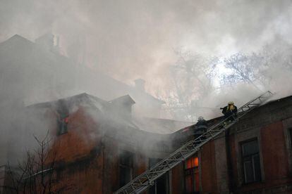 Los bomberos intentan apagar el fuego que envuelve uno de los edificios históricos ubicados en el patio del hotel Dnipro, en el centro de Kiev, (Ucrania).