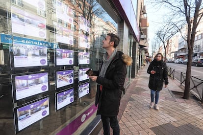 Un joven toma nota de pisos de agencia inmobiliaria