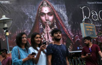 Varias personas pasan por delante de un cartel publicitario de la película 'Padmavati' en Bombay.