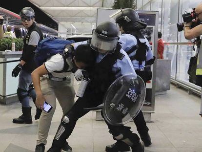 Enfrentamiento entre la policía y los manifestantes en el aeropuerto de Hong Kong.