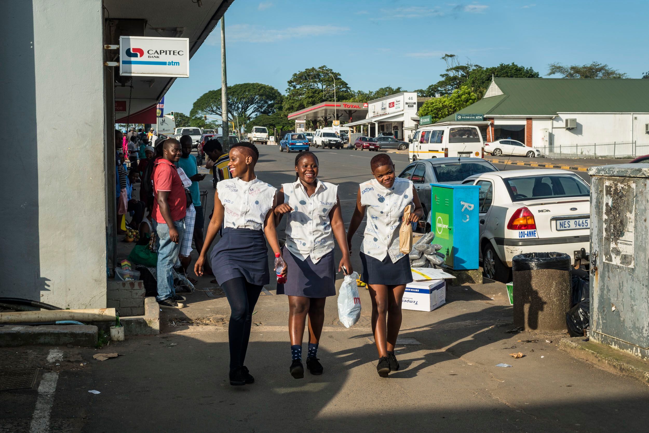 Nocembo, Oratile y Ahmale, compañeras de clase, caminan por la calle principal de Eshowe, en Kwazulu-Natal. Ellas consideran 