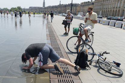 Un joven se refresca la cabeza en una fuente de Burdeos (Francia), el 22 de junio.