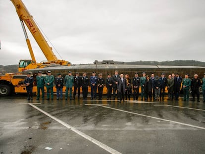 El delegado y la subdelegada del Gobierno en Galicia, Javier Losada y Maica Larriba, acompañados de diversos mandos policiales, ante el narcosubmarino hundido en Cangas (Pontevedra) tras ser reflotado por dos grandes grúas.