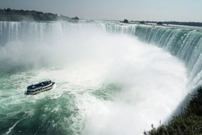 El barco turístico Maid of the Mist aproximándose al muro de agua de las cataratas del Niagara, frontera natural entre Canadá y Estados Unidos.
