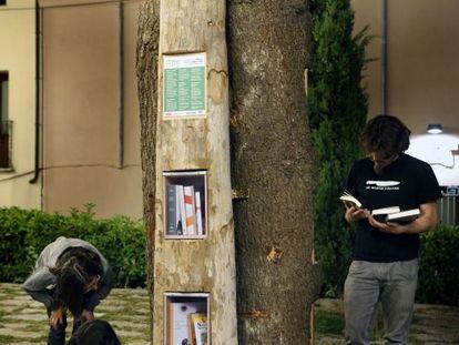 Unos j&oacute;venes consultan libros de intercambio en uno de los puntos del Arllibre instalados en Terrassa. 