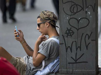 Un joven consulta su móvil en São Paulo (Brasil).