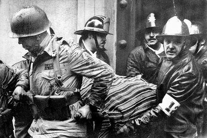 Soldados y bomberos sacan el cuerpo sin vida del presidente Salvador Allende, tapado con un poncho boliviano, del interior del palacio presidencial donde se suicidó tras el golpe de Estado del 11 de septiembre de 1973.