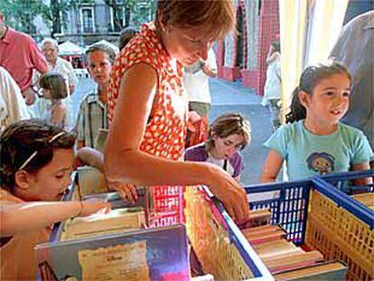 Vecinos curiosean en la parada de la biblioteca Antoni Julià de Capmany.