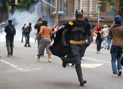Un hombre disfrazado de Batman corre durante los enfrentamientos entre manifestantes y policía en Río.