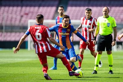 Messi, capitán del Barcelona, intenta regatear a Koke, capitán del Atlético de Madrid, durante un partido entre los dos equipos.