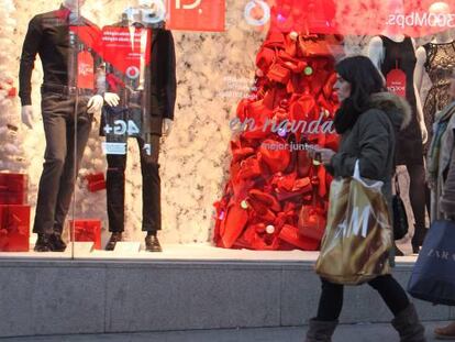 Dos mujeres pasan delante de un escaparate con motivos navideños.