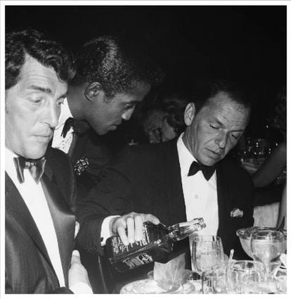 Frank Sinatra se echa una copa de Jack Daniel's bajo las miradas de Dean Martin y Sammy David en la famosa discoteca Cocoanut Grove (Los Ángeles), en julio de 1961.