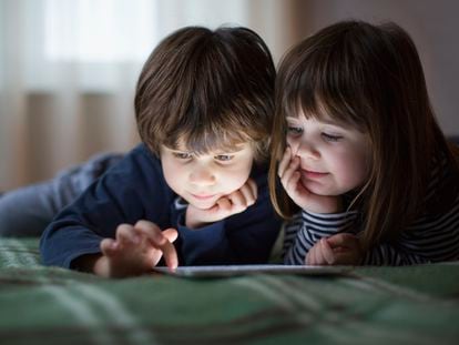 Dos niños juegan con su tableta.