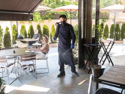 Marco, empleado del establecimiento Barbillon Oyster, desinfectando la terraza, esta mañana en Aravaca.