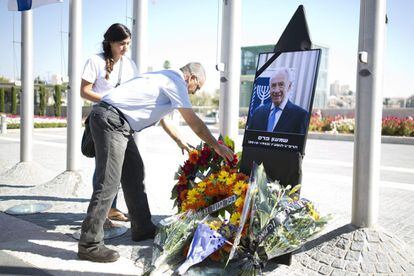 Un israelí coloca flores ante un retrato del expresidente israelí Simón Peres durante un acto público celebrado en el Parlamento o Kneset, en Jerusalén.