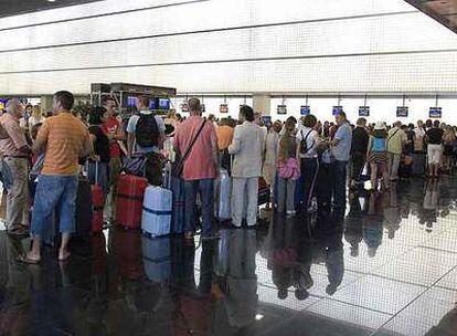 Viajeros haciendo cola ayer en la terminal B del aeropuerto de El Prat (Barcelona).