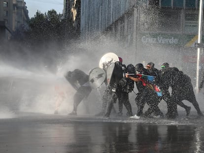 Manifestantes son reprimidos con agua a presión durante una protesta contra el Gobierno de Chile en Santiago el 20 de noviembre.