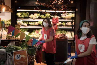 Dues voluntàries de l'ONG De Veí a veí recollint aliments al mercat de Sant Antoni.