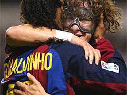 Puyol abraza a Ronaldinho tras marcar el brasileño uno de sus goles.