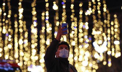 Un home fa una foto de l'enllumenat nadalenc al centre de Barcelona.