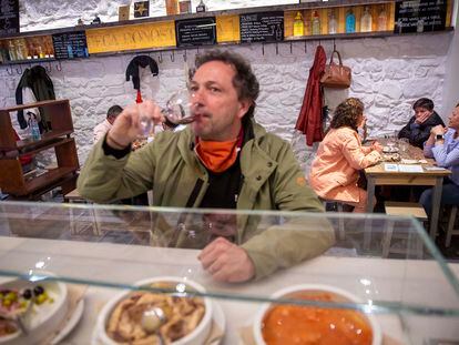 Un cliente toma un vino en la barra de la Bodega Donostiarra.