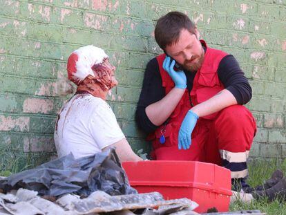 Un médico atendía este viernes a un herido de una zona residencial de Kiev.