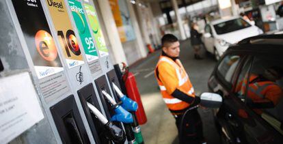 Un empleado echa combustible en un coche en una gasolinera de la carretera de Extremadura.