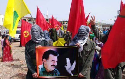 Kurdos enmascarados sujetan un retrato del l&iacute;der del PKK, Abdal&aacute; Ocal&aacute;n, el 4 de abril, en Urfa, en el sur de Turqu&iacute;a.