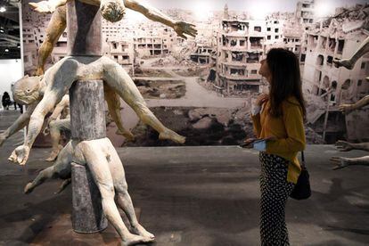 Una mujer observa la instalación 'Alepo' de Francisco Leiro.