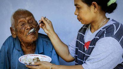 law Suwarni, de 43 años, da de comer a su abuelo Sodimejo el pasado 2 de marzo de 2017 en su casa en Sragen, Java Central.