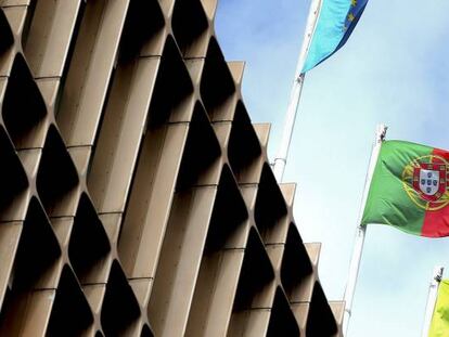 La bandera portuguesa, la europea y la de un banco luso ondean en un edificio. 