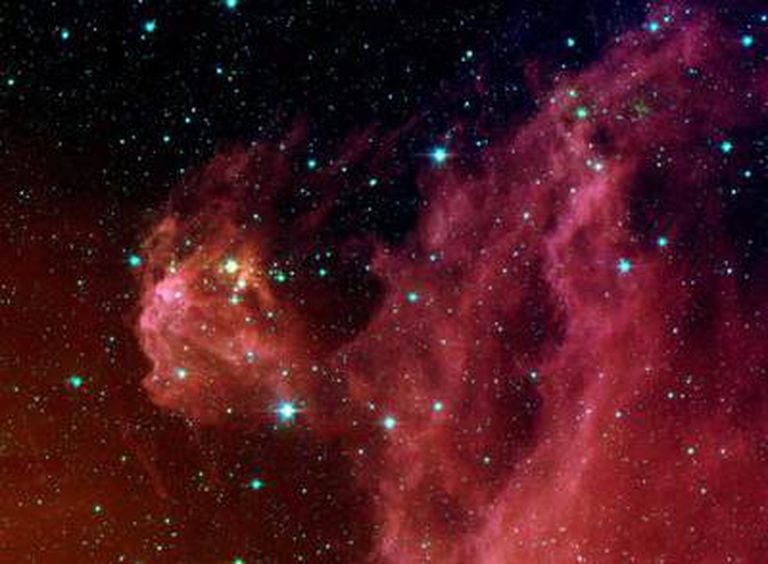 Estrellas nacientes, dentro de nubes rojizas, en Orión, a 1.300 años luz de la Tierra.