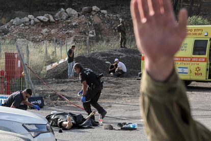 Expertos forenses inspeccionan el cuerpo sin vida de una de las víctimas, en el lugar de un ataque en el asentamiento judío de Eli, en el norte de la Cisjordania.