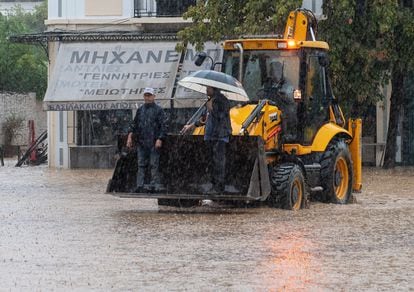 Tres civiles trabajan en una excavadora para ayudar durante la tormenta 'Daniel', este martes en la zona de Volos (Grecia).