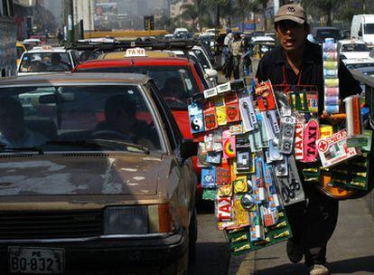 Un vendedor callejero ofrece sus productos en pleno atasco de tráfico en una céntrica calle de Lima