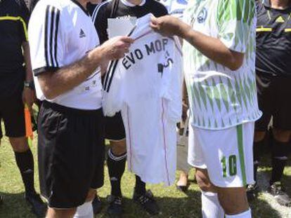 Butragueño le regala una camiseta del Madrid a Evo Morales antes del partido.