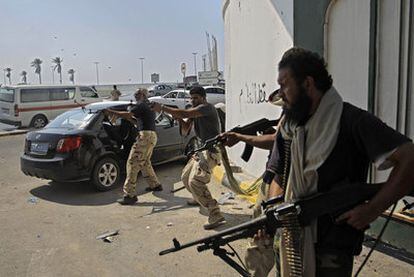 Combatientes rebeldes disparan en un enfrentamiento contra las tropas leales a Gadafi ayer en el centro de Trípoli.