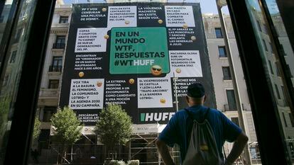 Un transeúnte observa la lona desplegada por El HuffPost en la calle Gran Vía de Madrid, este jueves.