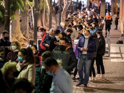 Cientos de personas esperan para hacerse un test de antígenos o vacunarse de la primera dosis contra el coronavirus, este jueves en Murcia.