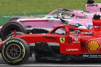Sebastian Vettel (en el monoplaza de Ferrari) trata de adelantar a Sergio Pérez en una carrera de Fórmula 1 el año pasado.