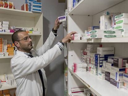 Un farmacéutico busca un medicamento en su oficina de Sevilla.