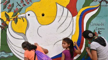 Dos colombianas pintan un mural por la paz.