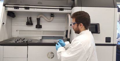 Un ingeniero de HP con piezas fabricadas en 3D para el circuito respiratorio diseñado por el Hospital Príncipe de Asturias.
