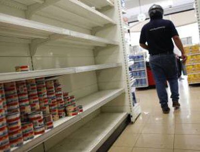 Un cliente recorre un pasillo con estanterías desabastecidas en un supermercado en Caracas (Venezuela). EFE/Archivo