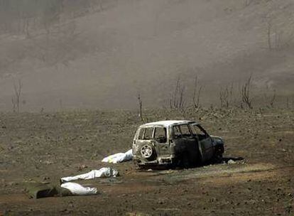 Tres cadáveres de agentes forestales, junto al vehículo todoterreno calcinado en el que viajaban el 17 de julio de 2005.